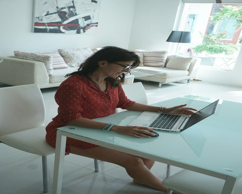 Woman looking away from laptop screen in modern home office